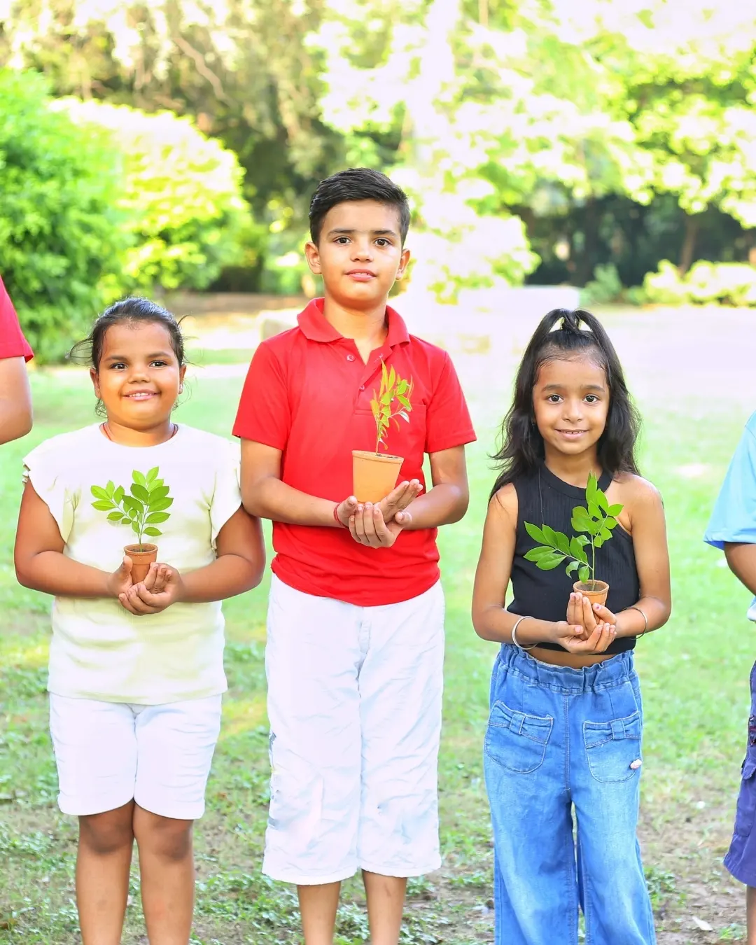 Children proudly holding plants they grew at a community garden