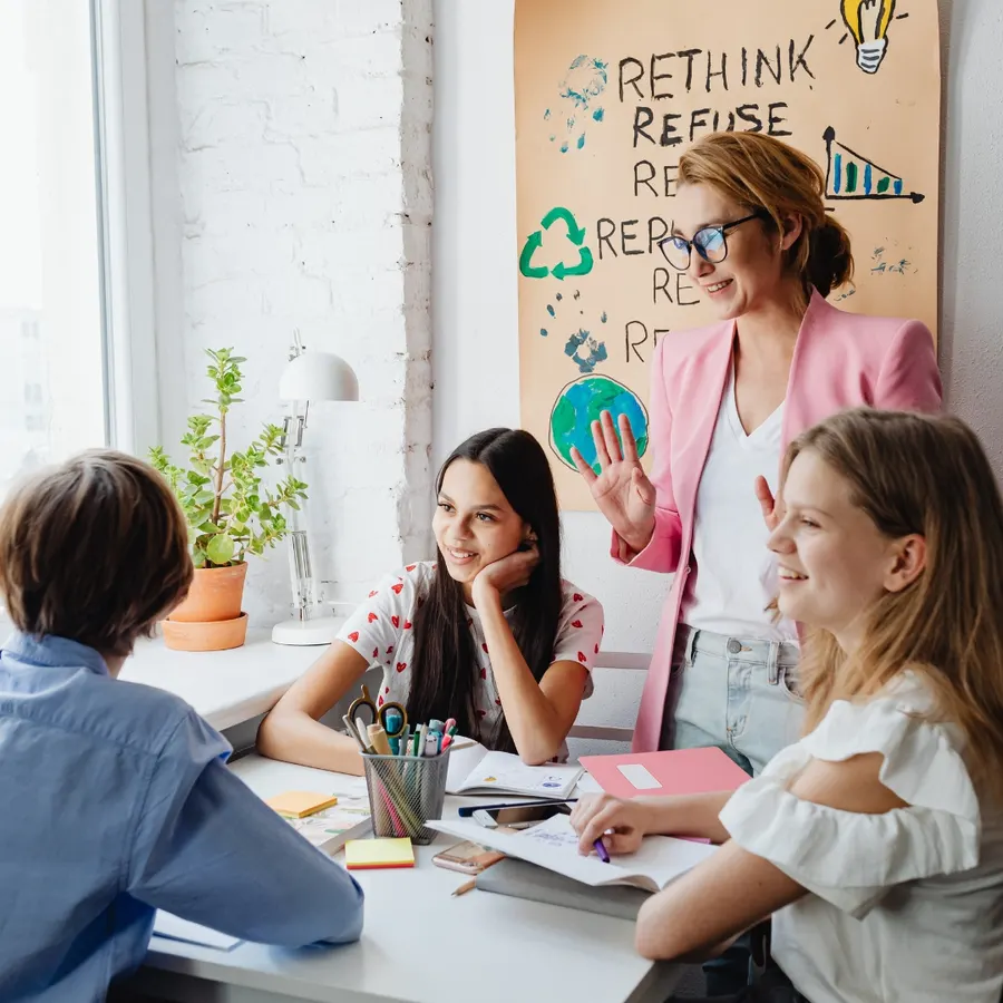 A mentor working with young people around a table